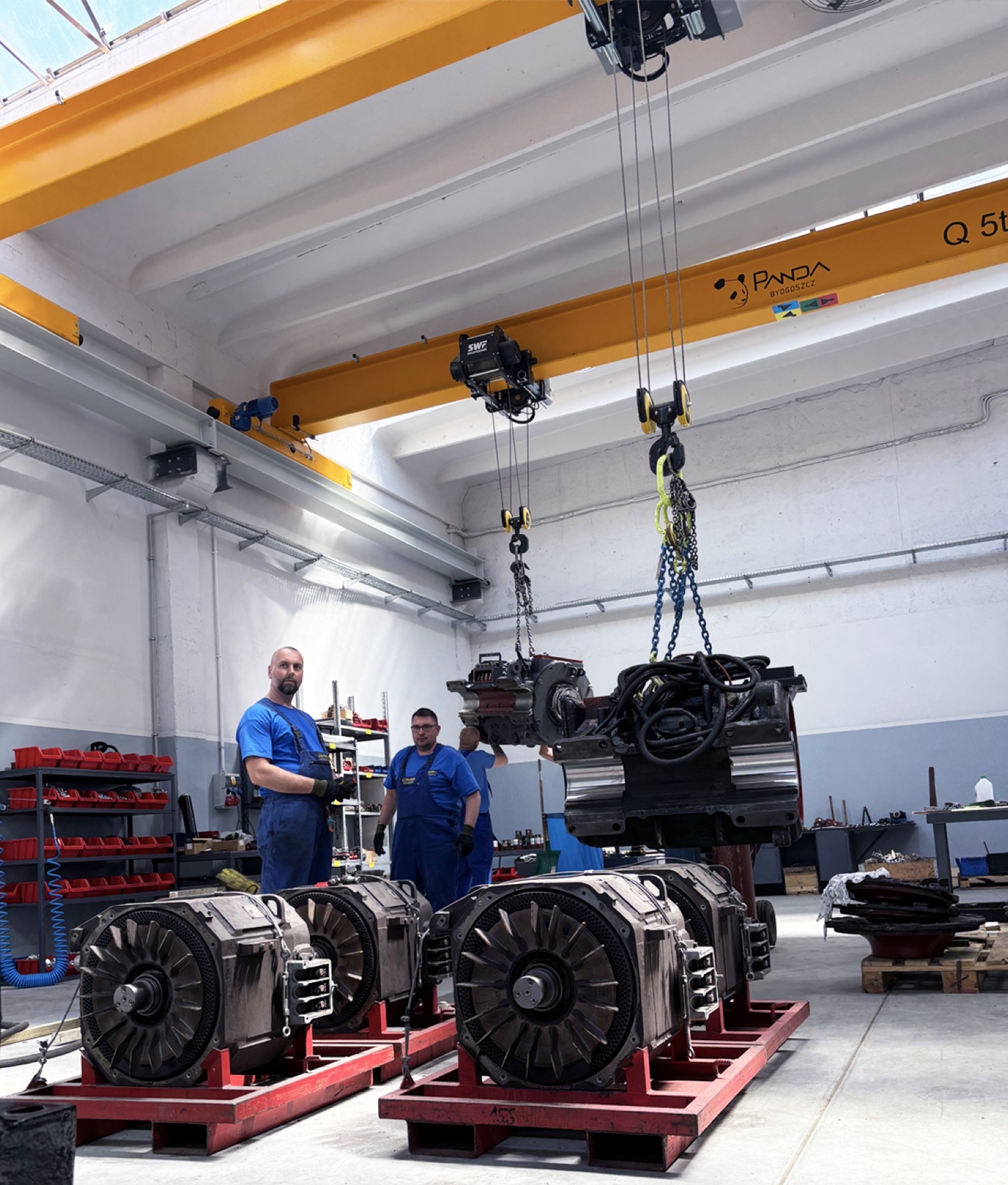 Zespół Zakładu Elektromechanicznego ELREM Sp. z o.o. podczas remontu dużej maszyny elektrycznej w hali produkcyjnej